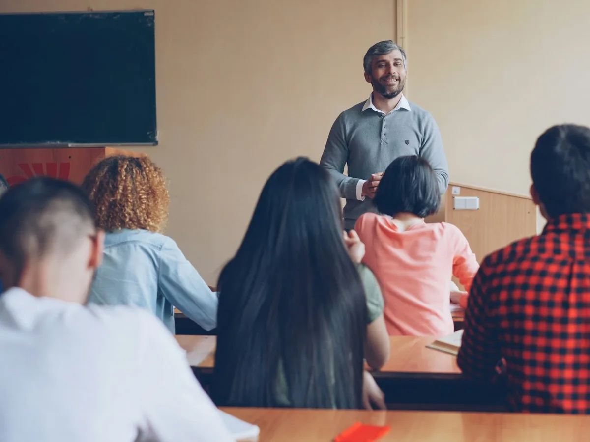 An experienced teacher leading a lesson at the front of the class