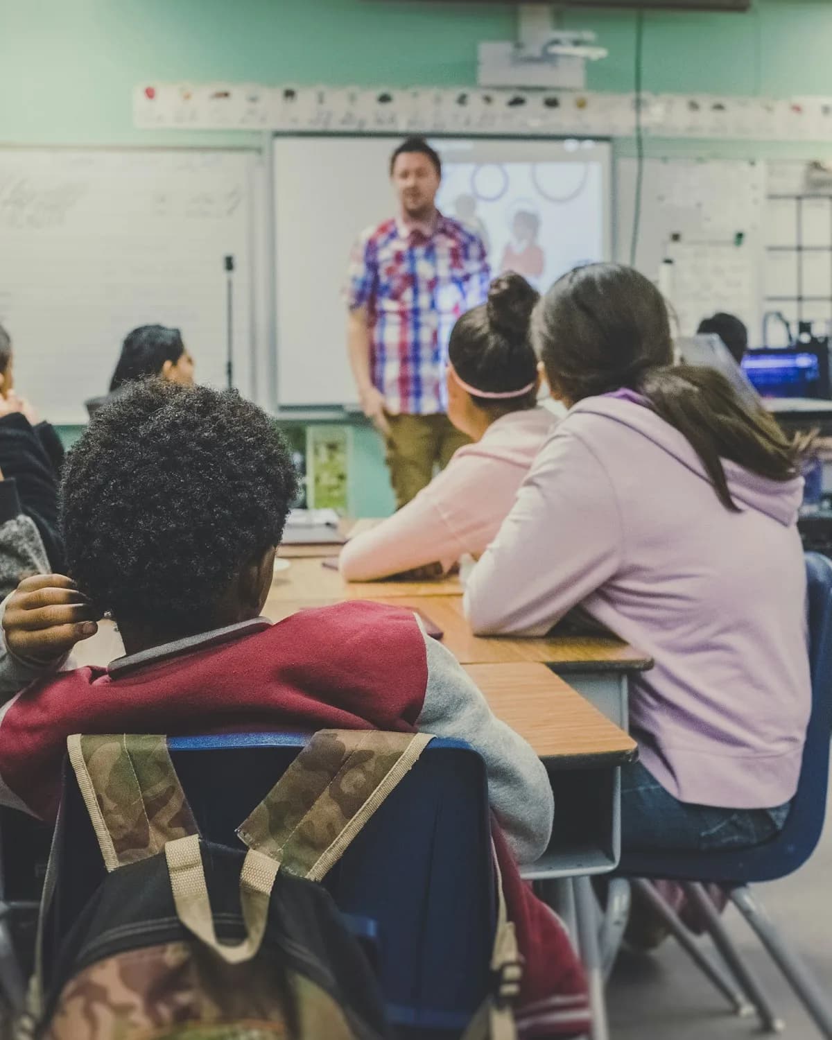 A secondary classroom seen from the back, the teacher at the front