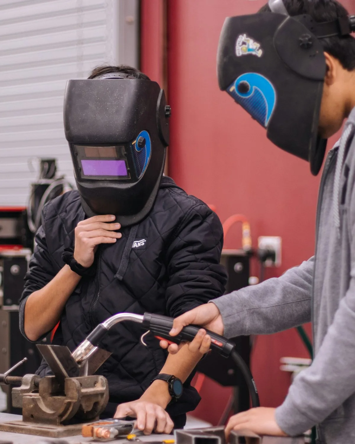 Two learners welding in a college workshop