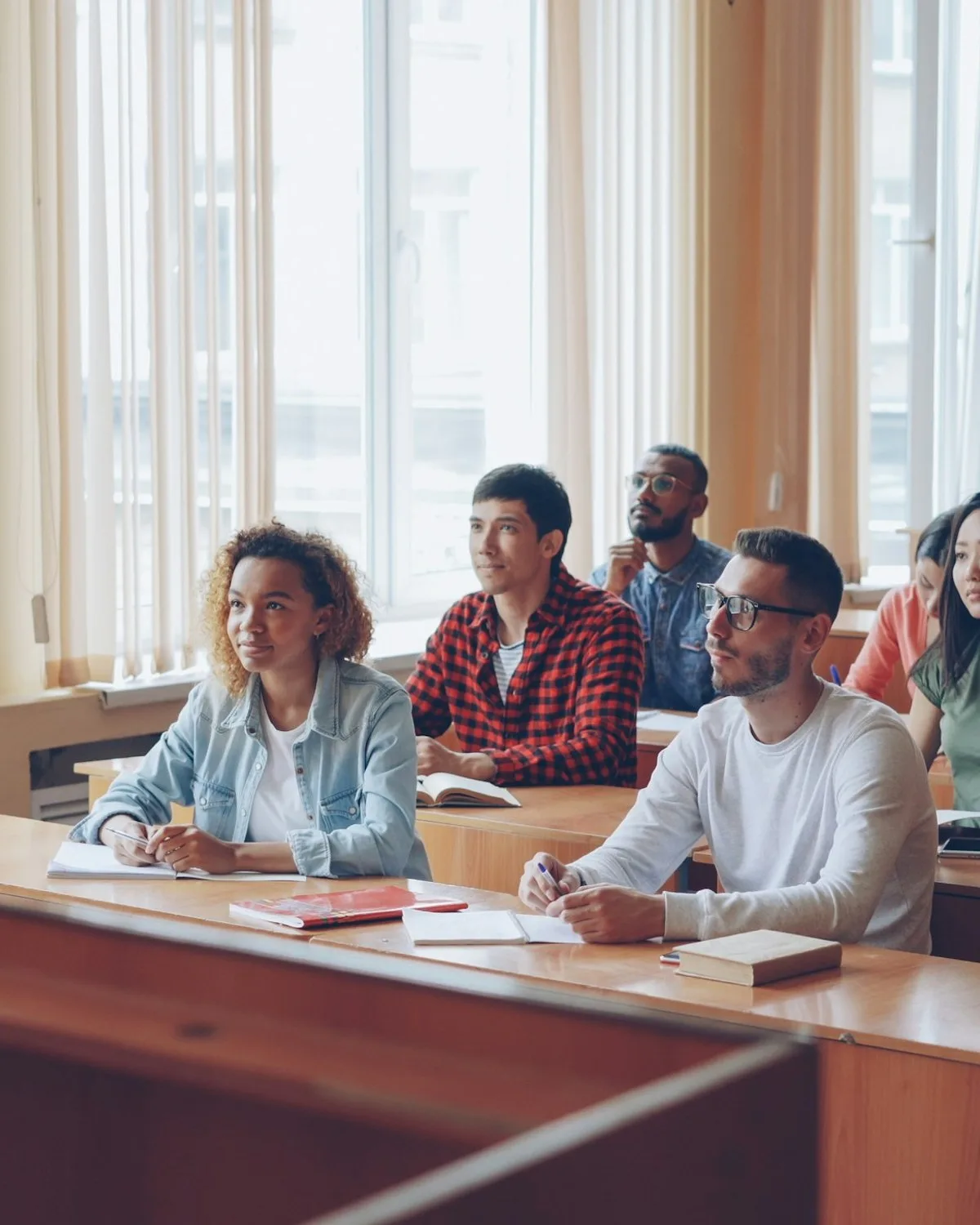 A lecturer talking with students in a bright university seminar room